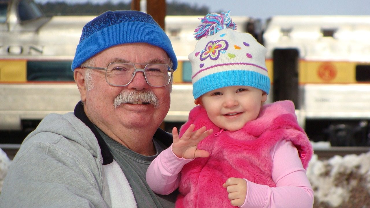 A grandfather holding his granddaughter.